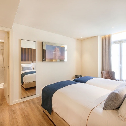 um quarto de hotel com duas camas e um espelho