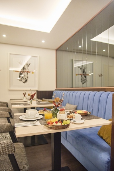 uma sala de jantar com mesas e sofás azuis