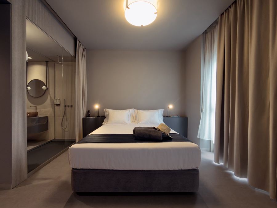 a hotel room with two beds and a flat screen tv that says magni sun