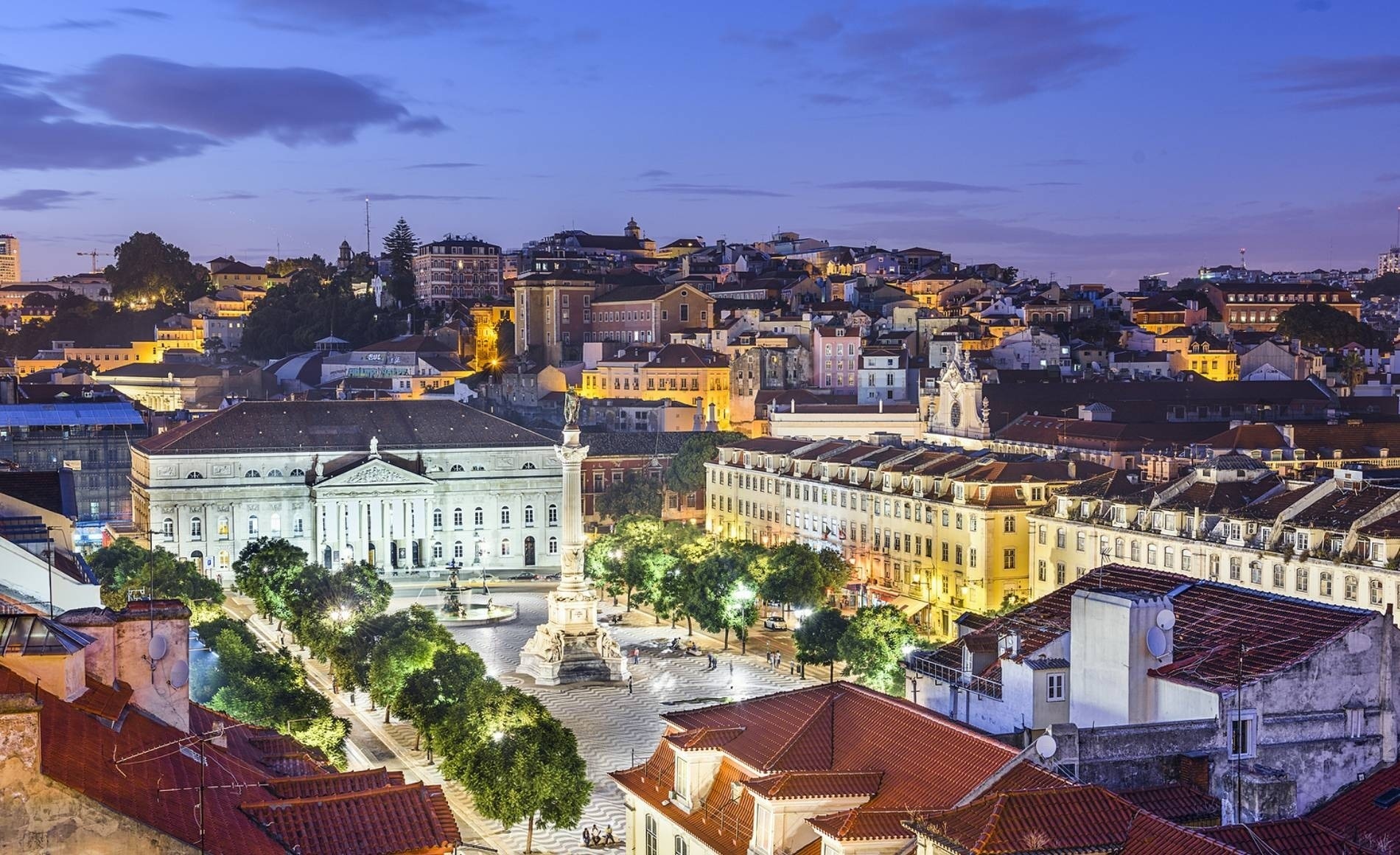 an aerial view of a city with a statue on top of a building