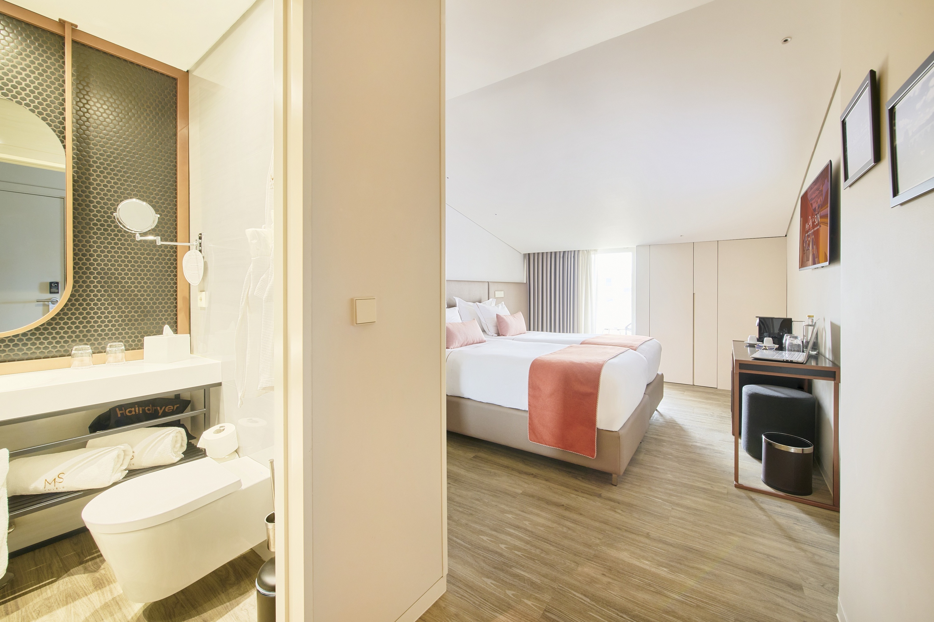 una habitación de hotel con dos camas y un inodoro