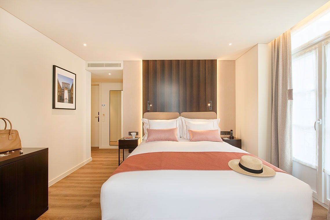 um quarto de hotel com uma cama e um chapéu