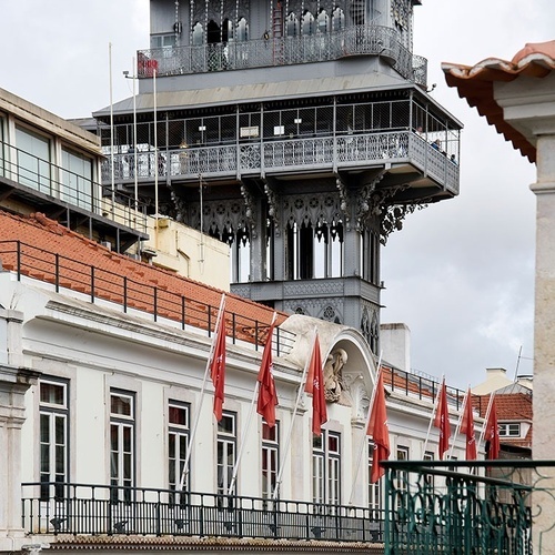 un edificio con banderas rojas y blancas y un elevador en el fondo