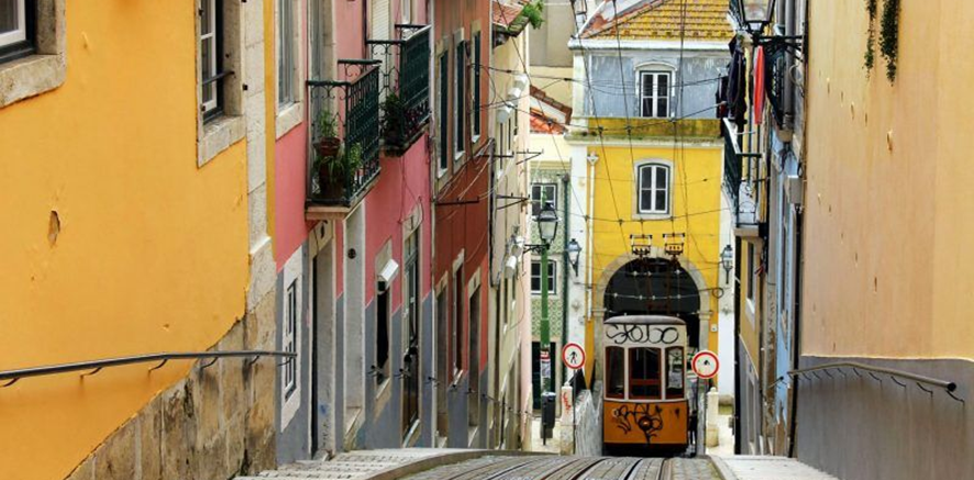um bonde sobe uma rua íngreme ao lado de prédios coloridos .