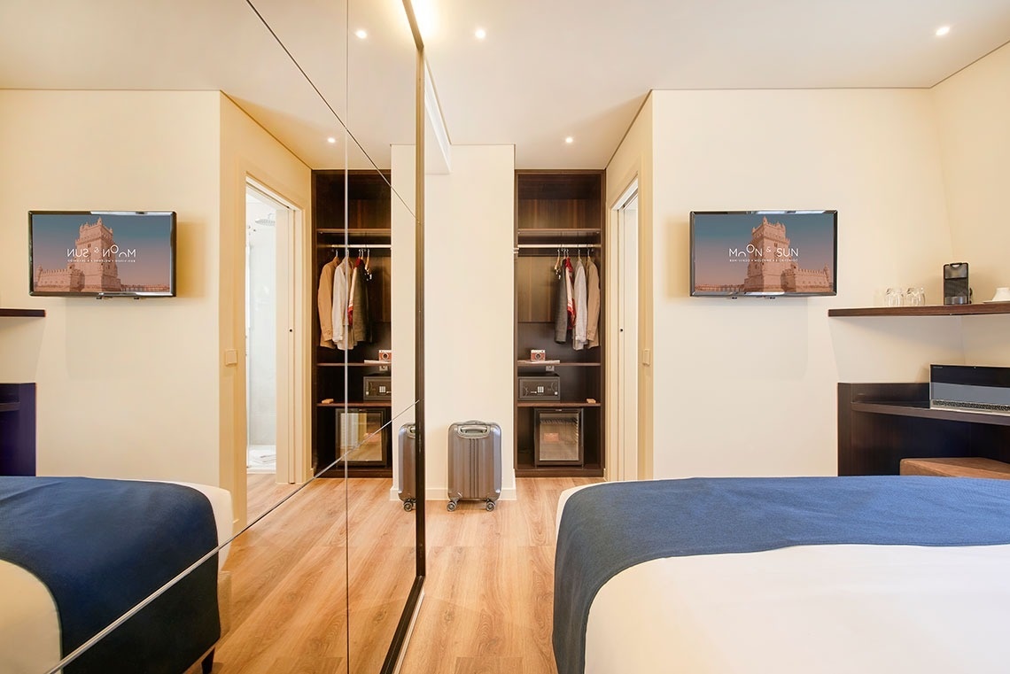 um quarto de hotel com duas camas e duas telas