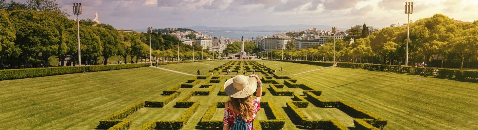 a woman in a hat is standing in a park