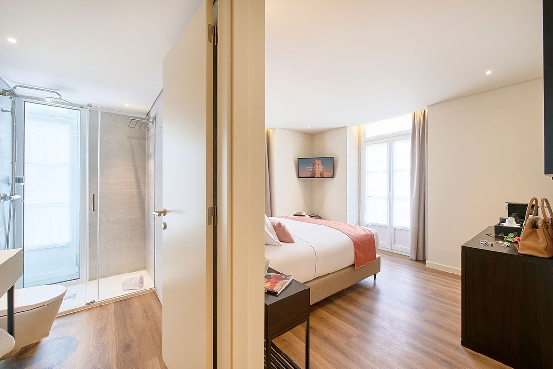 a hotel room with a bed and a television on the wall