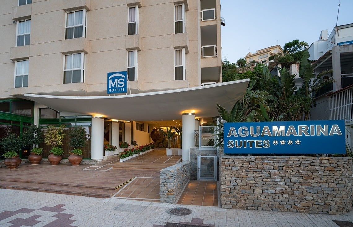 un edificio de apartamentos con un cartel azul que dice aguamarina suites