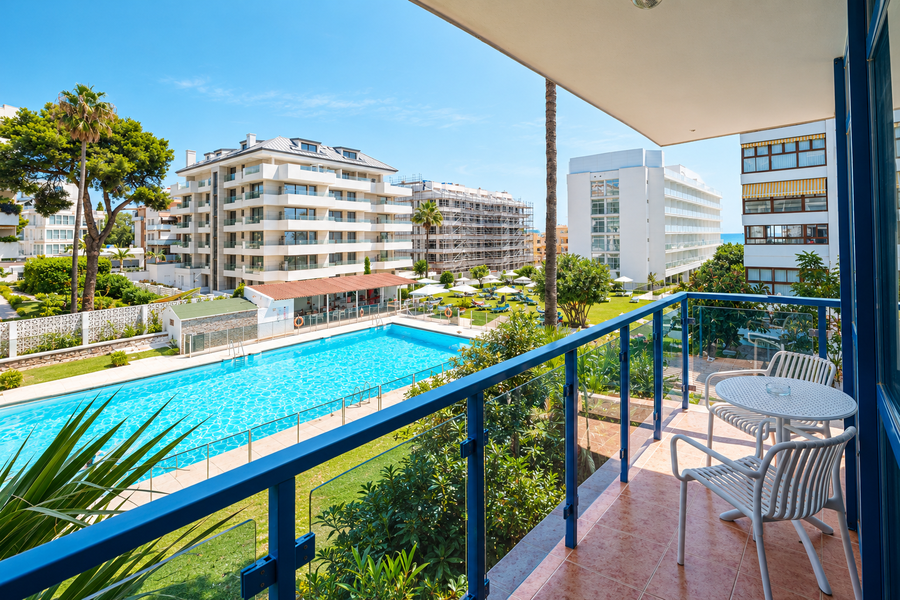 Balcón con vistas a piscina y edificios modernos. MS hoteles: Puerto Marina.