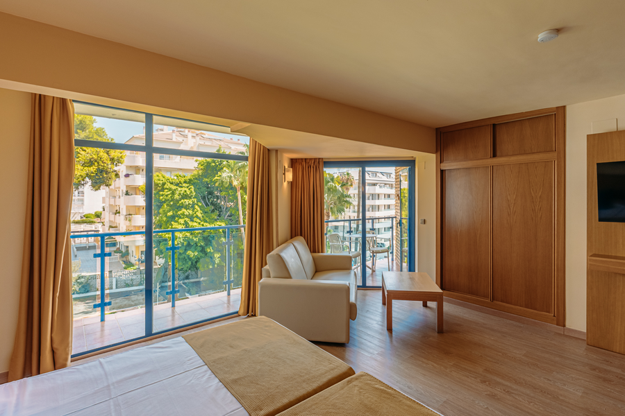 Habitación luminosa con balcón y vista exterior, sofá, mesa de centro y MS hoteles: Puerto Marina.