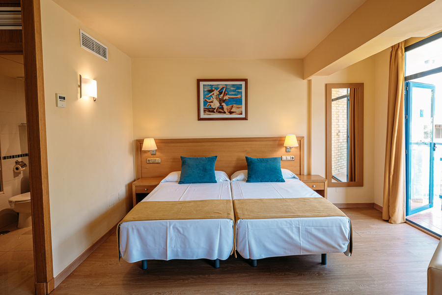 Habitación de hotel con dos camas individuales y cojines azules. MS hoteles: Puerto Marina