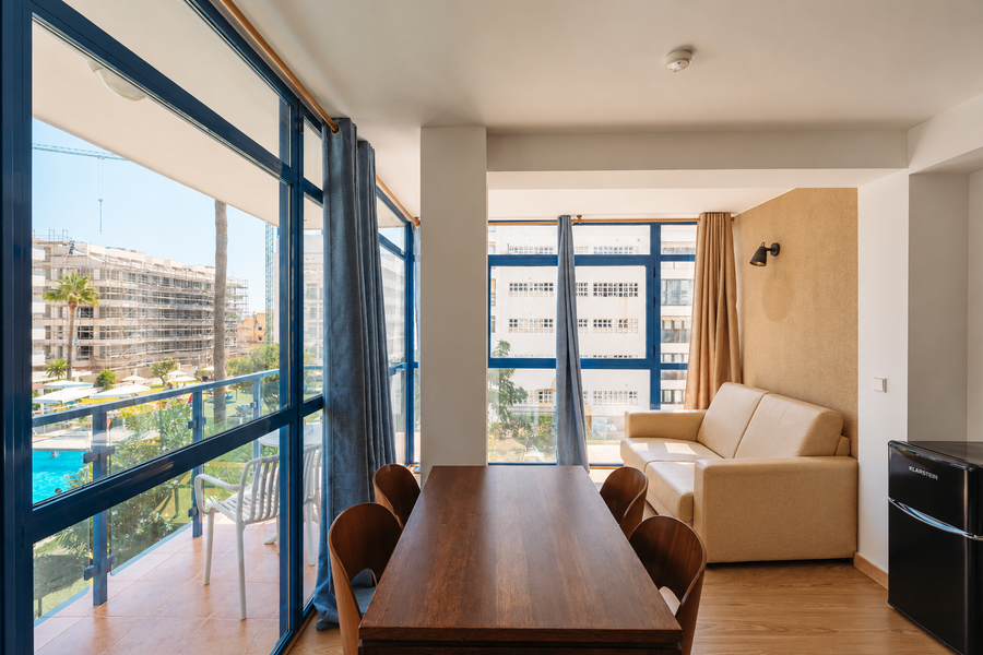 Comedor y sala de estar con vistas a la piscina y construcción en curso MS hoteles: Puerto Marina.