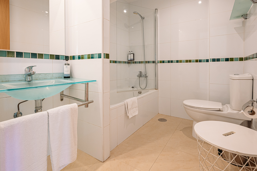 Baño moderno con ducha, inodoro, lavabo y toallas limpias. Un lugar perfecto para tu estancia. MS hoteles: Puerto Marina
