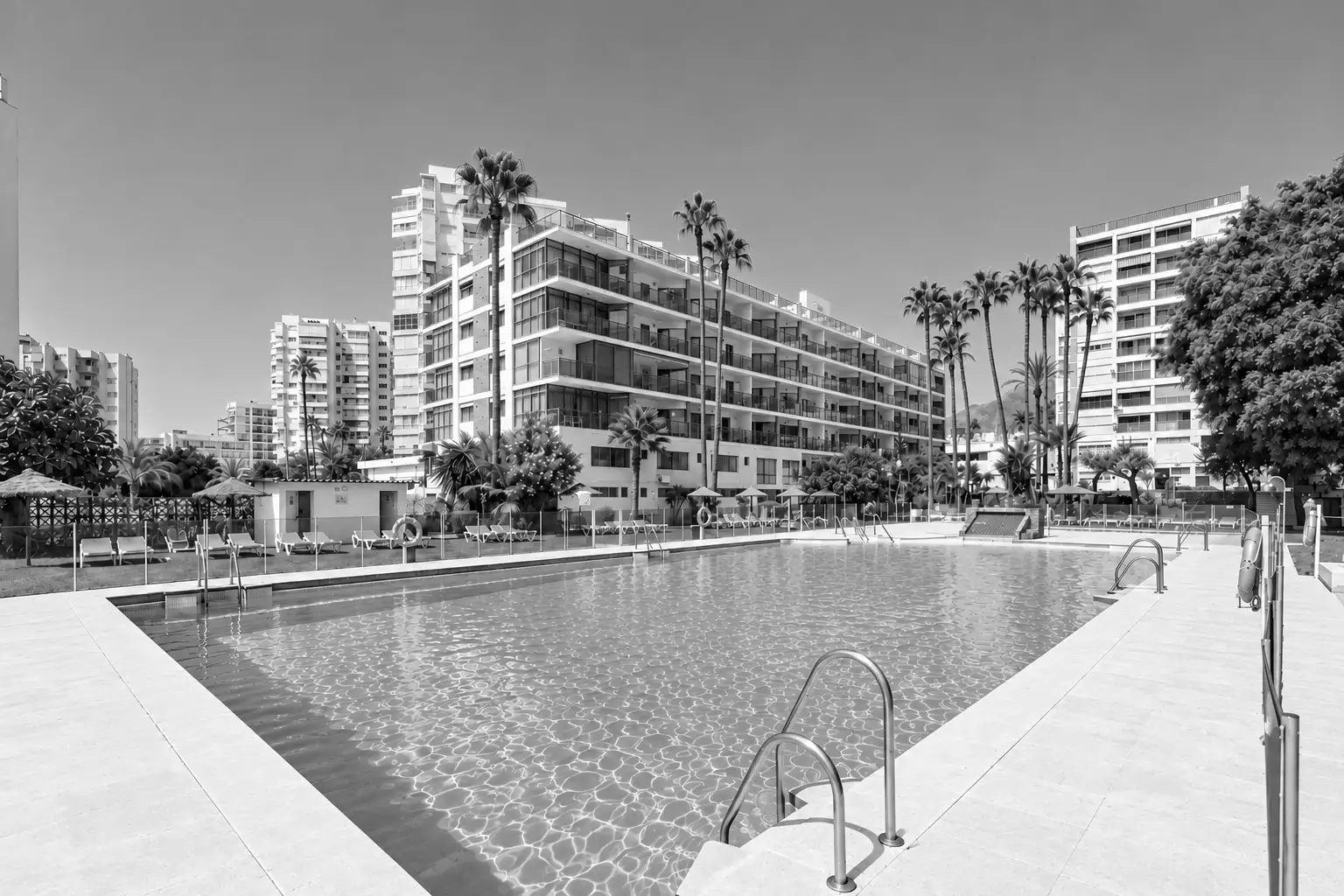 Piscina del hotel con palmeras y edificios modernos, cerca de MS: Puerto Marina.=s1900
