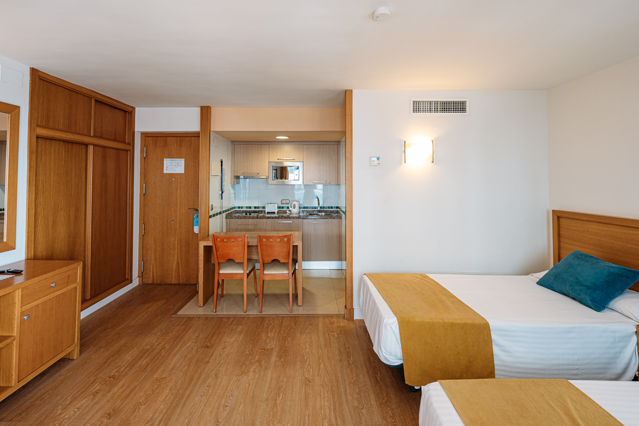 Habitación de hotel con cama y cocina americana, ideal para estancias cómodas. MS hoteles: Puerto Marina