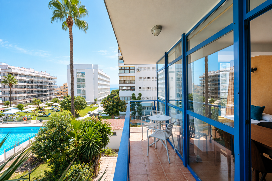 Balcón de hotel con vistas a piscina y palmeras. MS hoteles: Puerto Marina