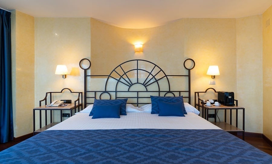 una habitación de hotel con una cama y dos mesitas de noche