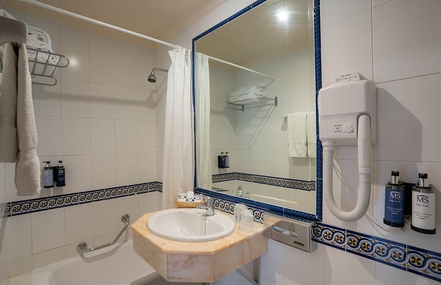 un baño con un lavabo y un secador de pelo ms