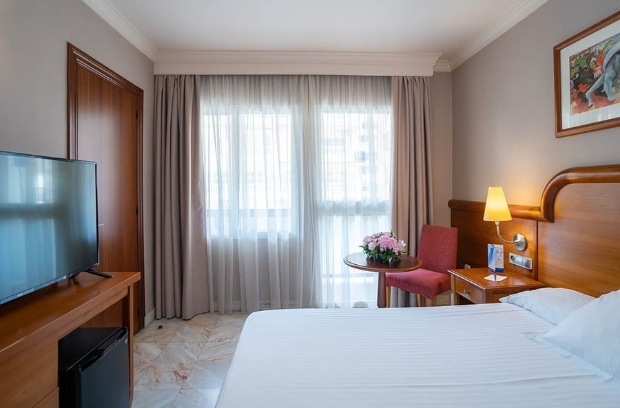 una habitación de hotel con una cama y una televisión