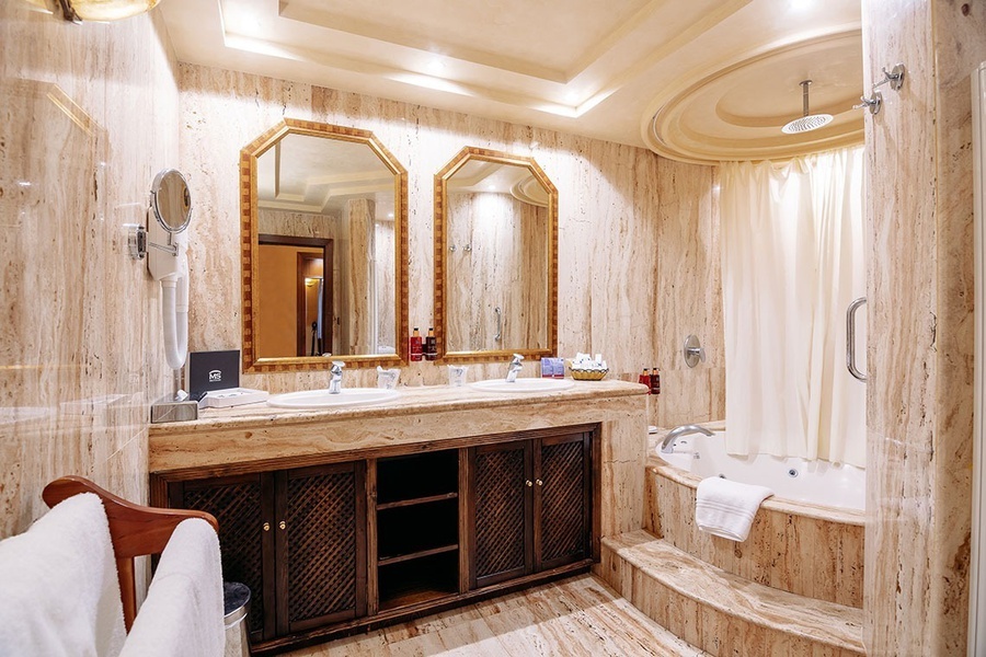 un baño con dos lavabos y una bañera