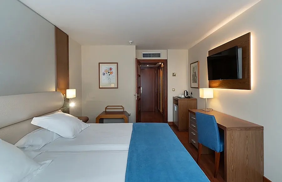 Habitación de hotel moderna con MS: Maestranza, TV y escritorio.