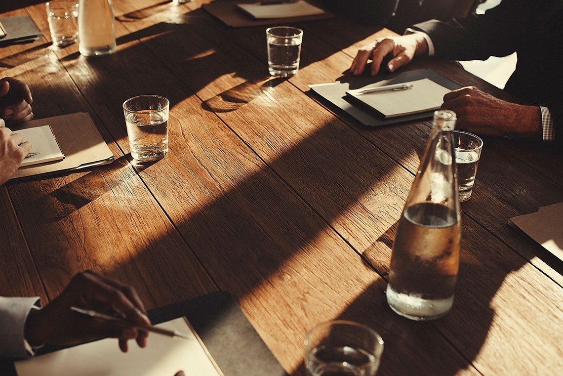 una mesa de madera con una botella de agua y vasos de agua