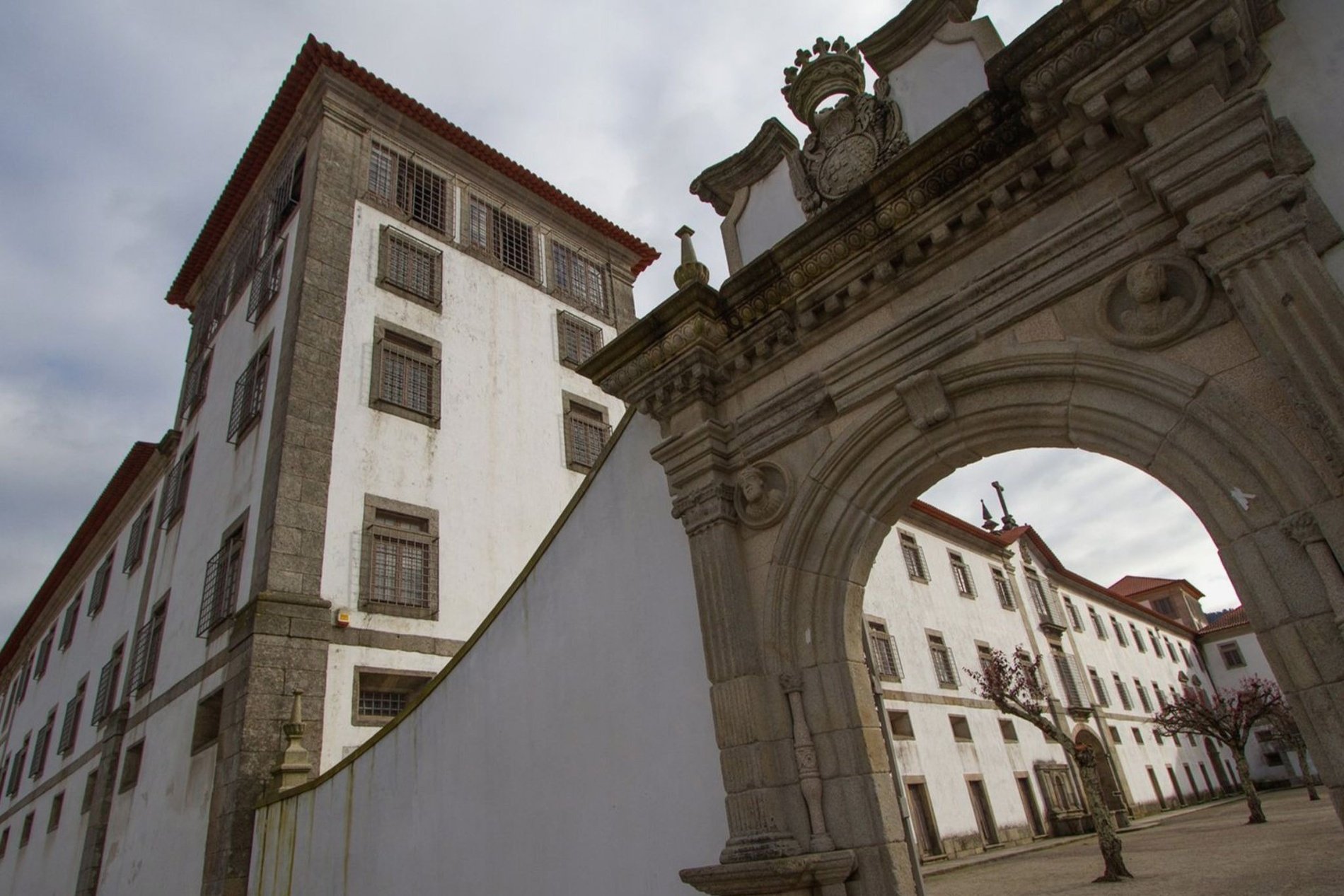 un edificio blanco con un arco de piedra y una corona en la parte superior