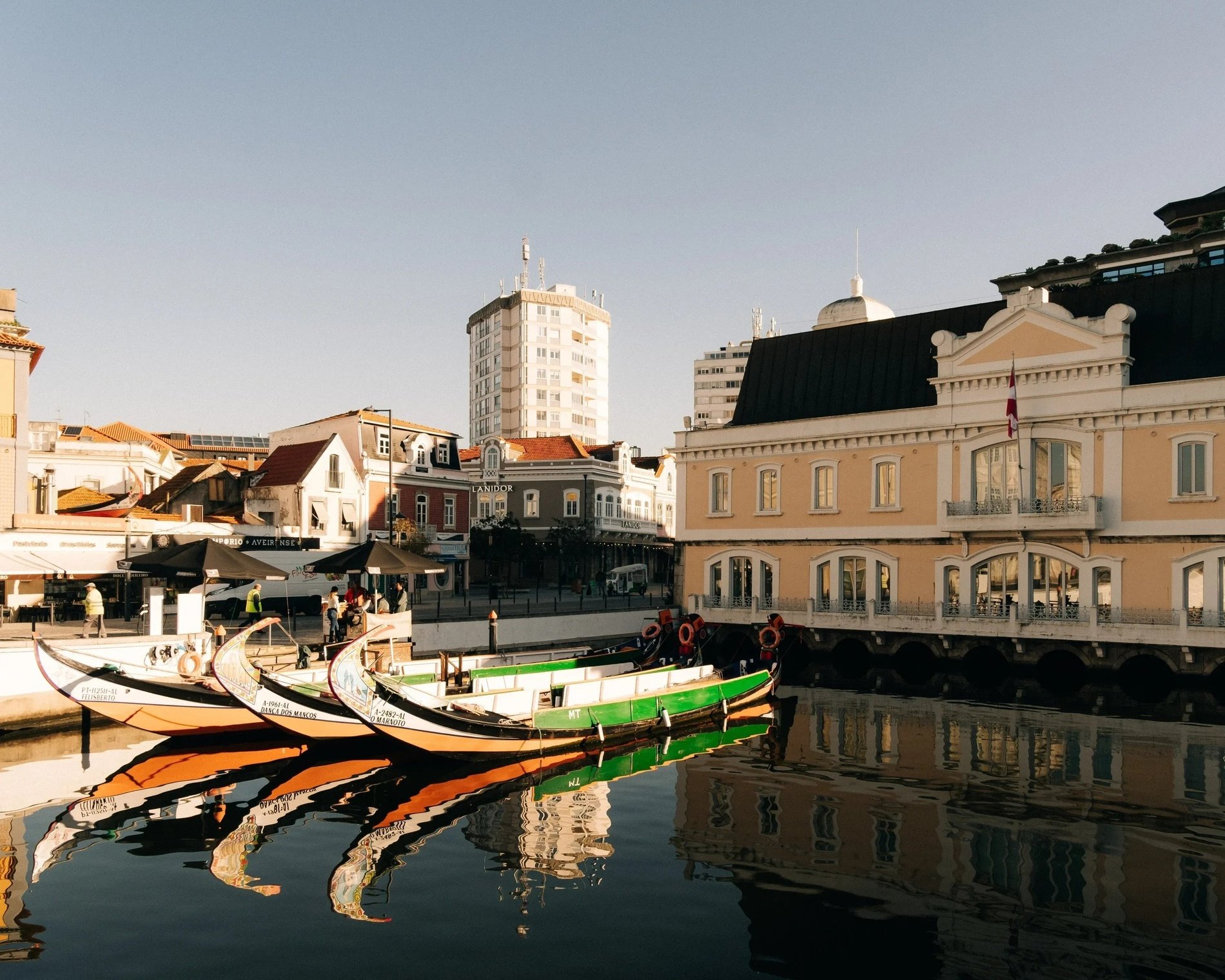 a row of boats are docked in front of a building with a sign that says ' farmacia ' on it