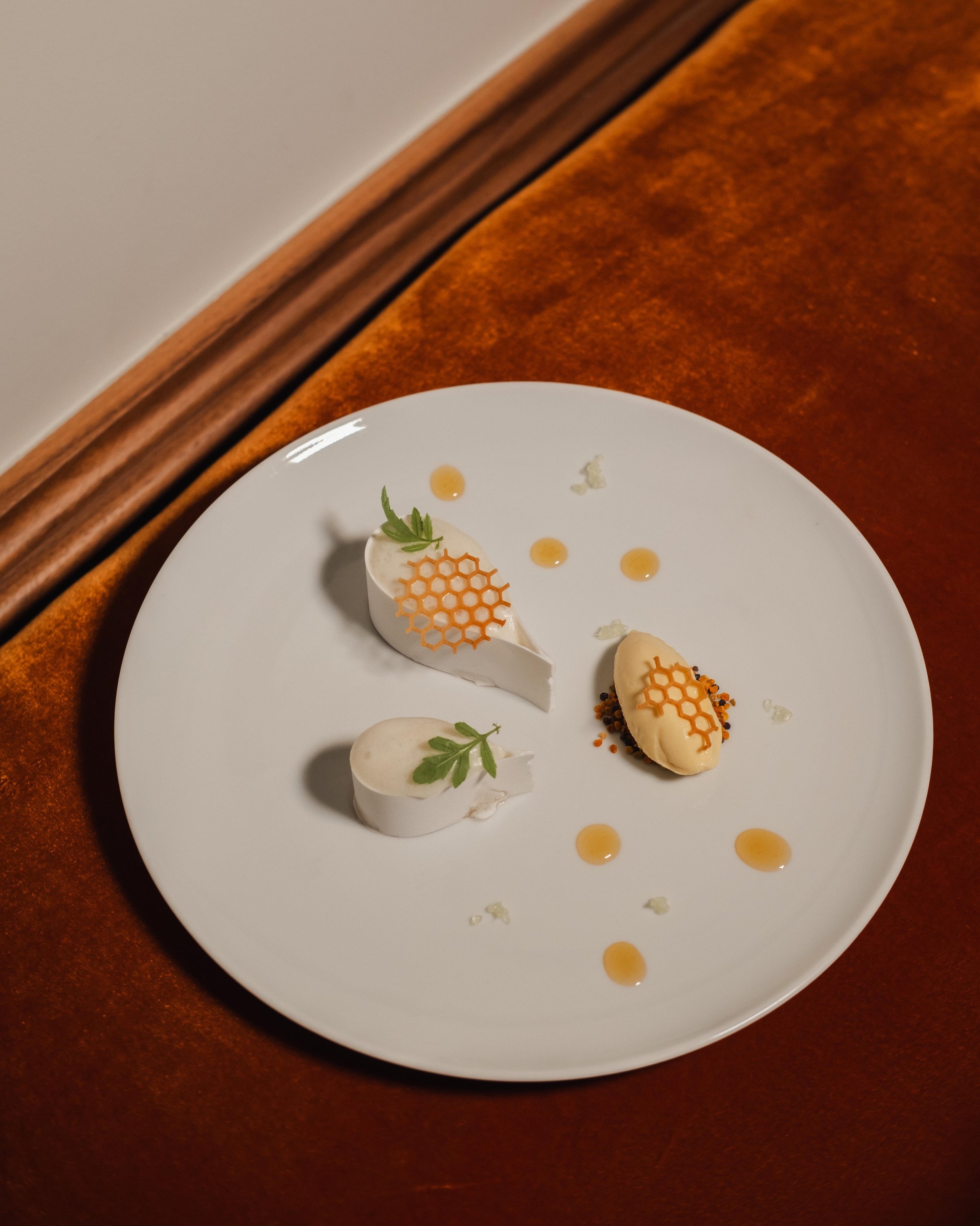 un plato blanco con un trozo de queso y un trozo de helado