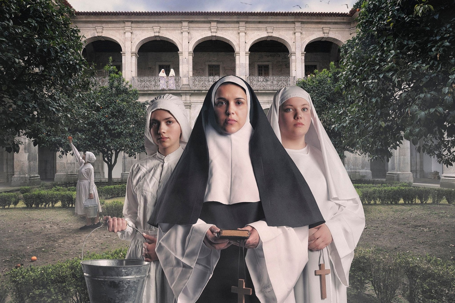 três freiras estão posando para uma foto em frente a um prédio