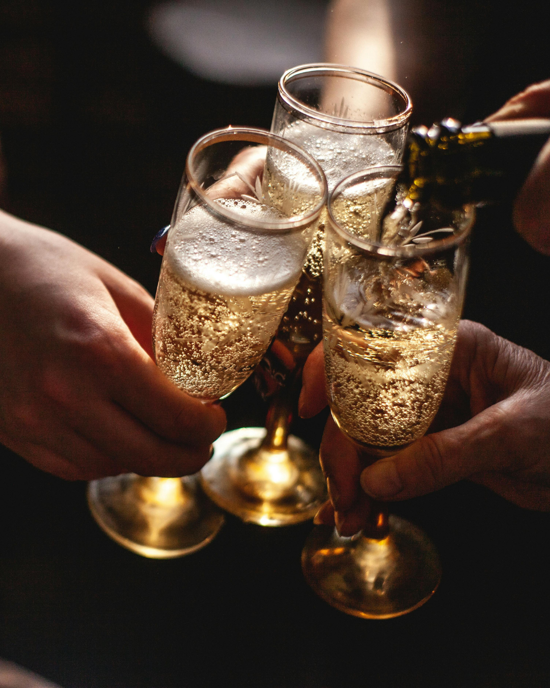 a bottle of champagne is being poured into three glasses