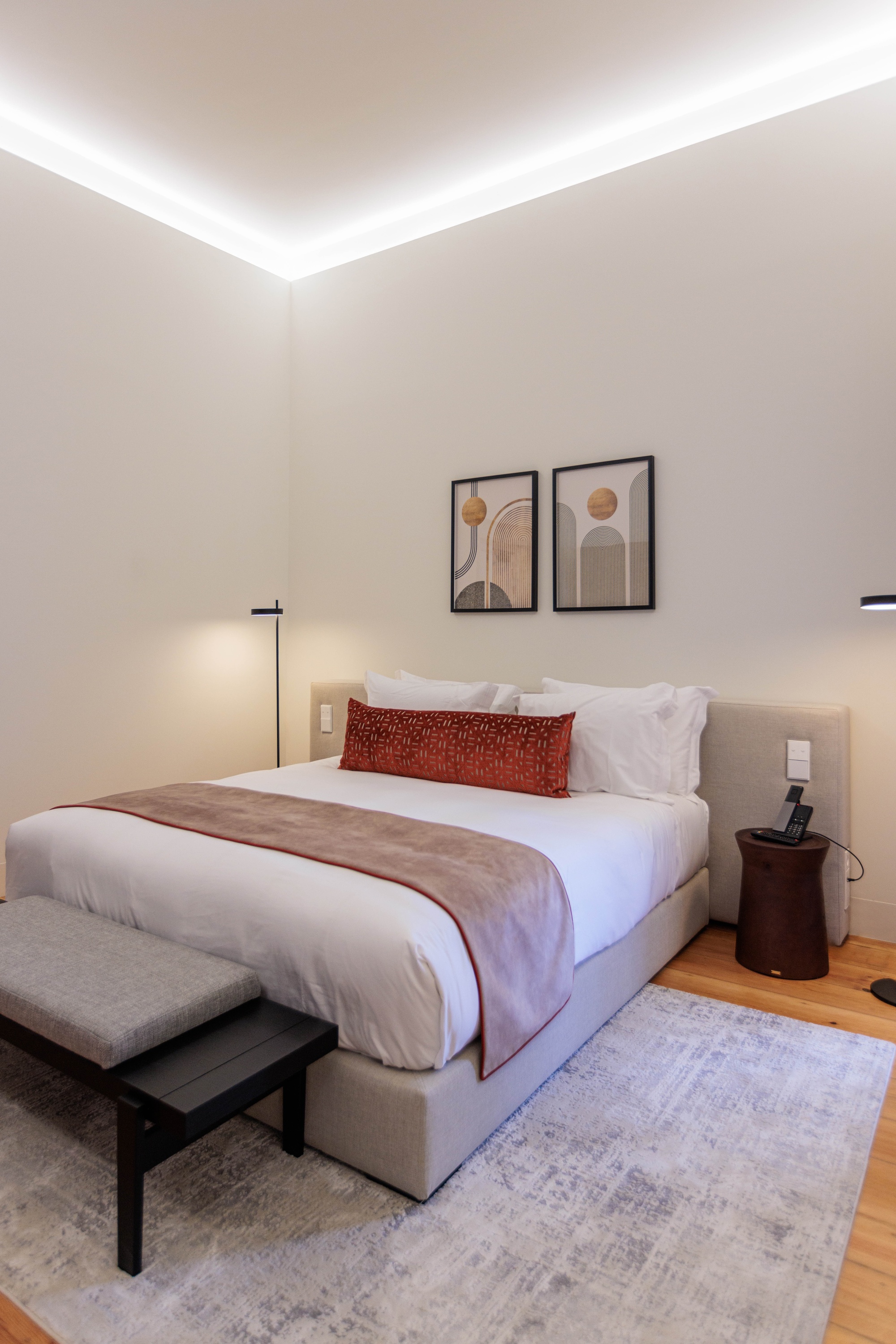 a bedroom with two beds and a bench with a purse on it