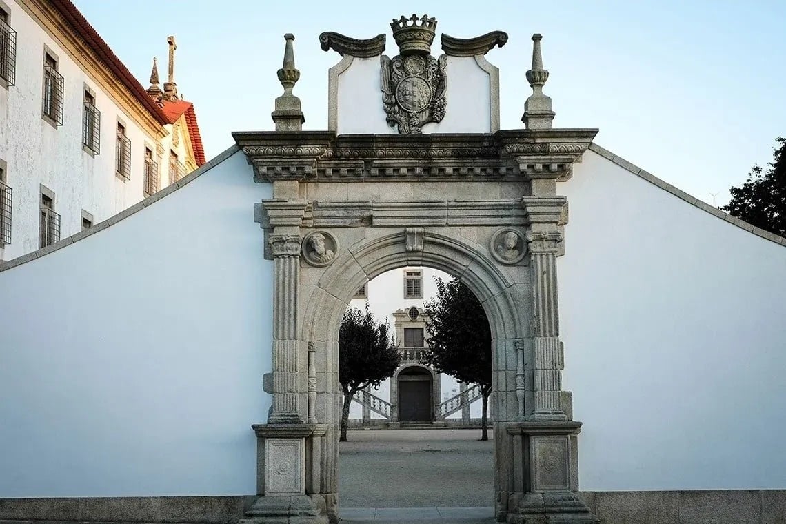 um edifício branco com um arco de pedra sobre ele