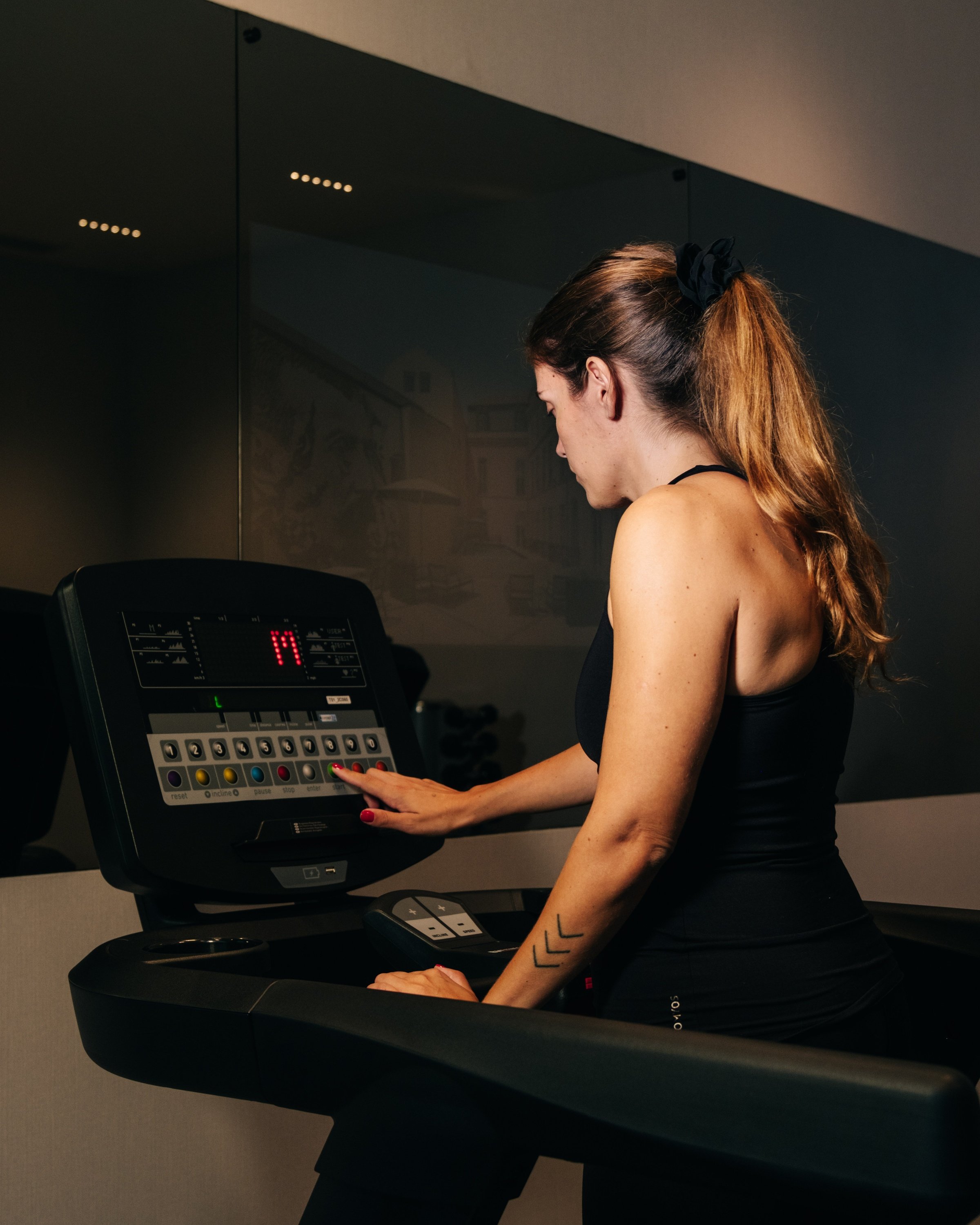 una mujer corre en una cinta de correr con el número 19 en la pantalla