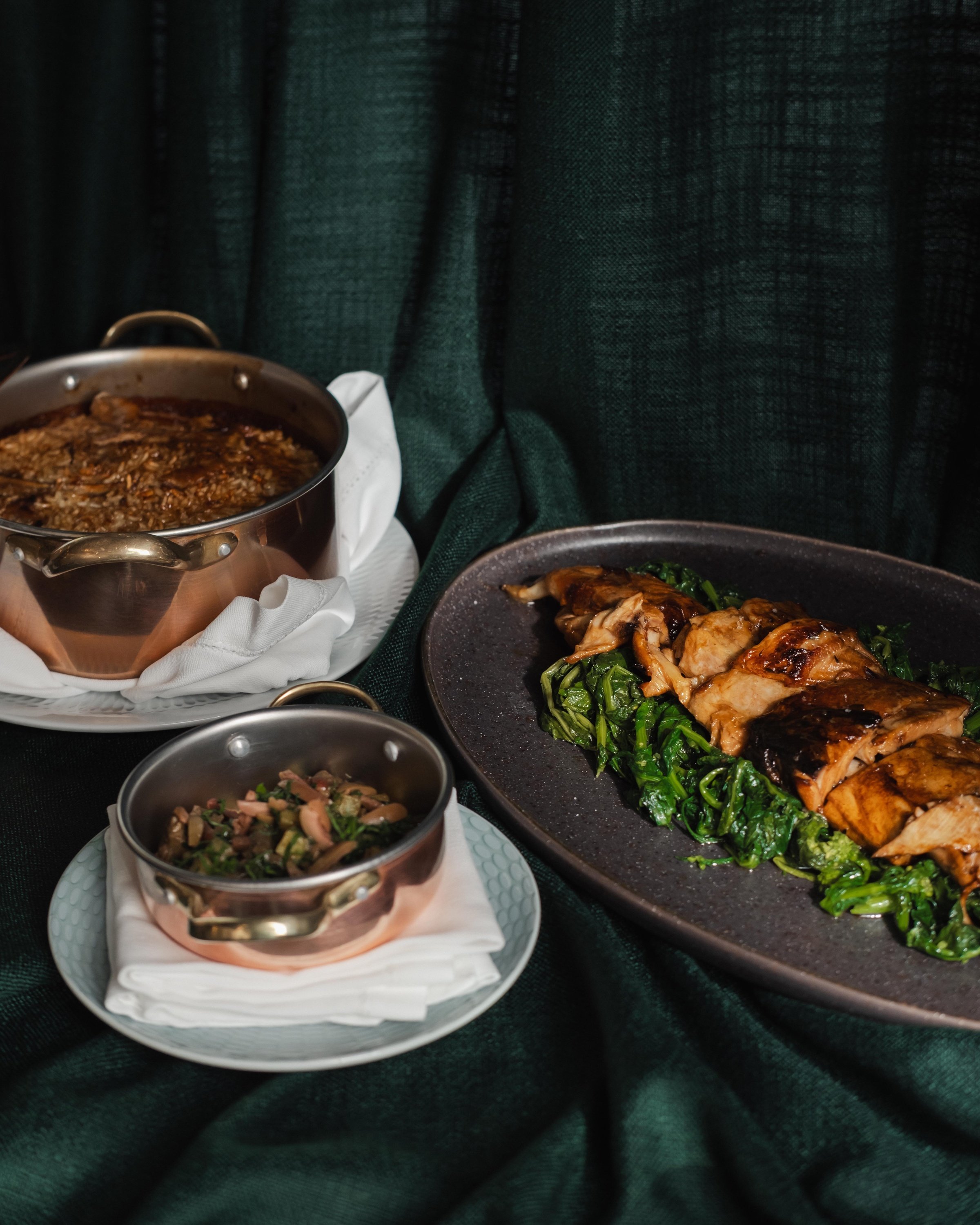 tres platos de comida están sobre una mesa verde