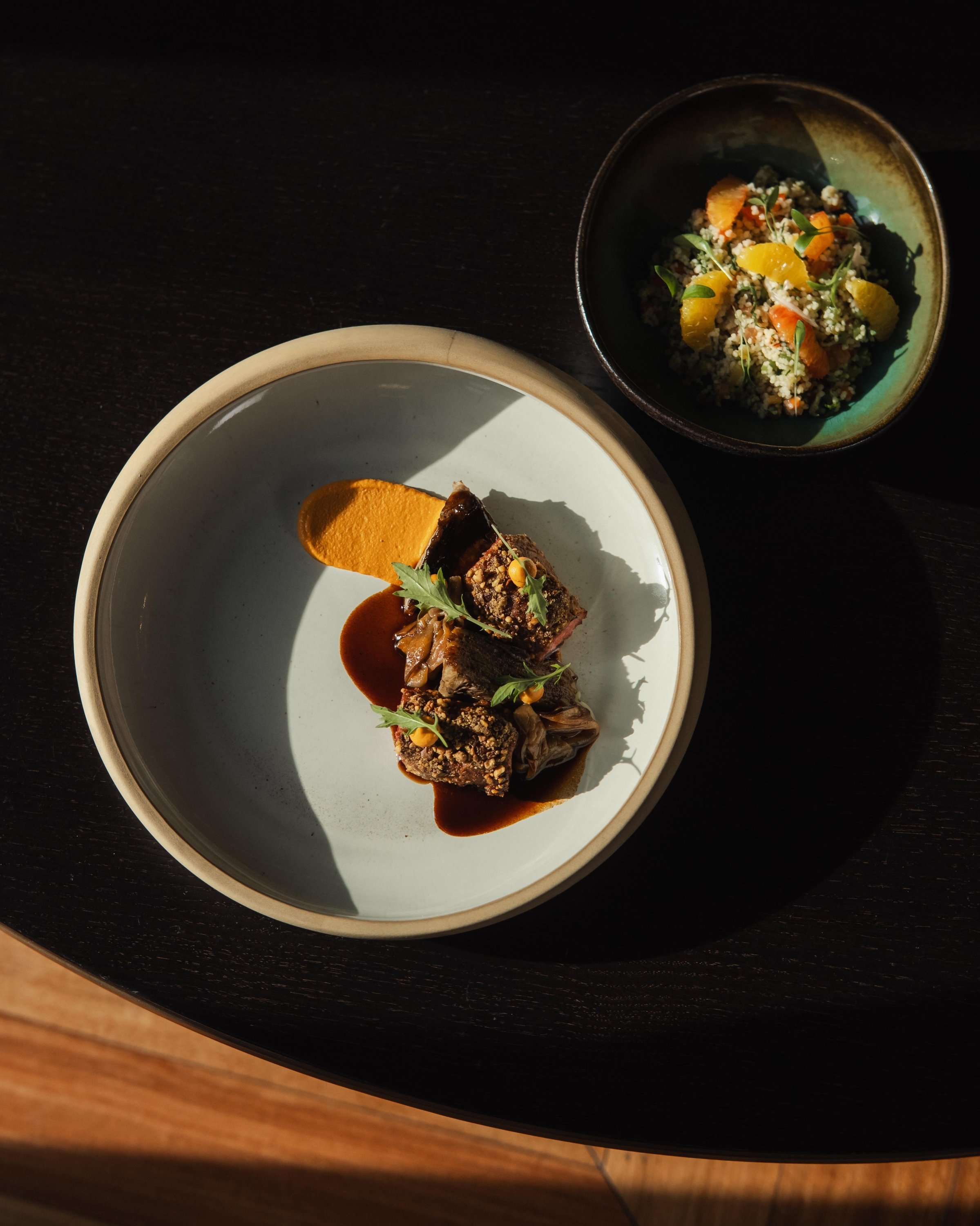 un plato de comida está sobre una mesa junto a un tazón de comida