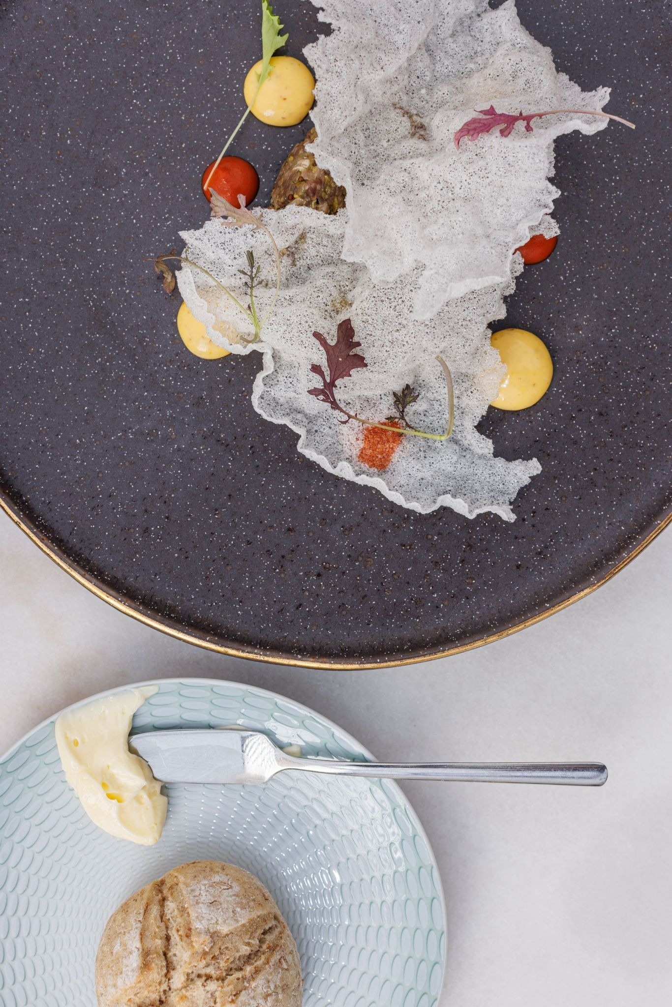 a plate of food next to a plate of butter