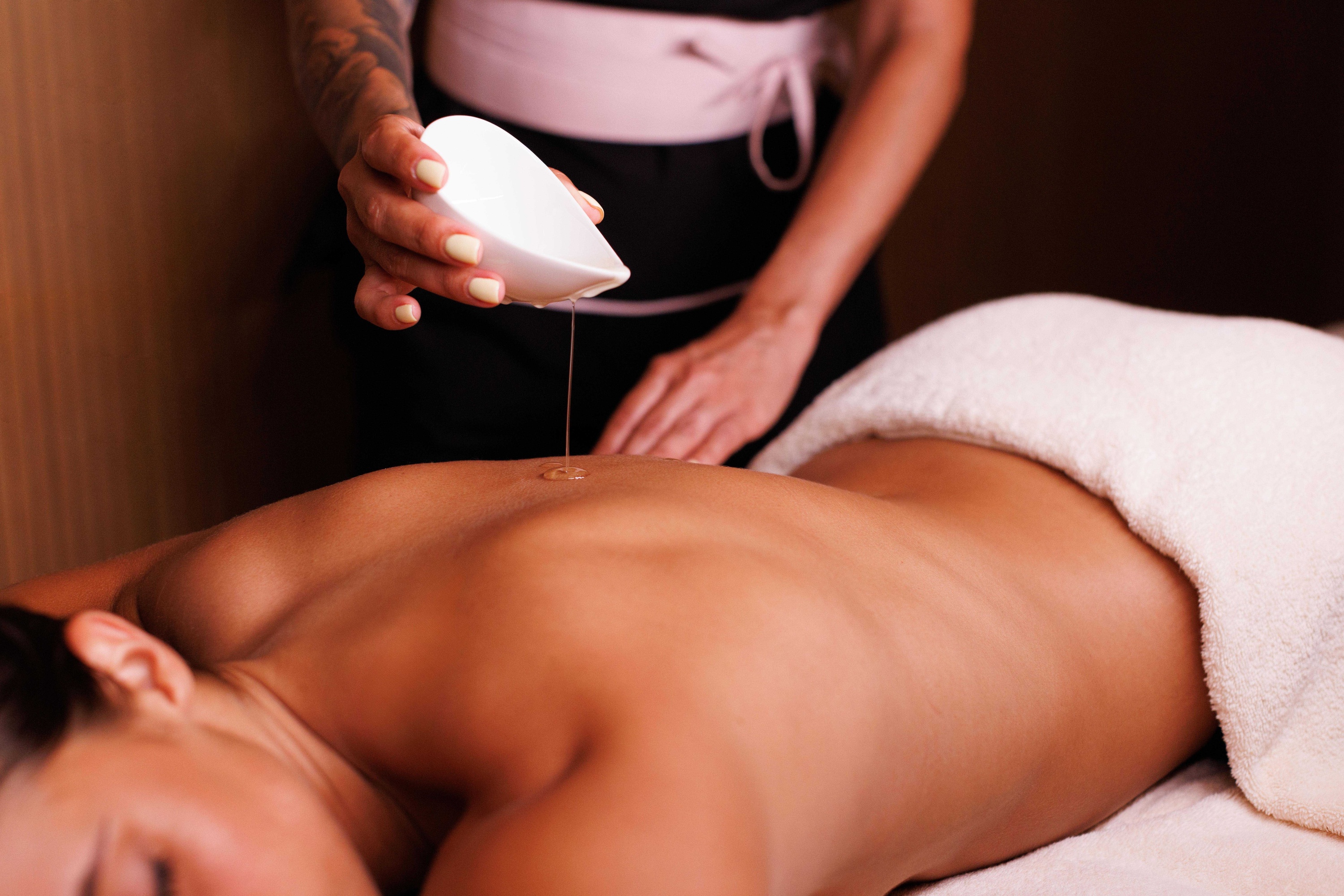 uma mesa de massagem em uma sala com paredes de madeira