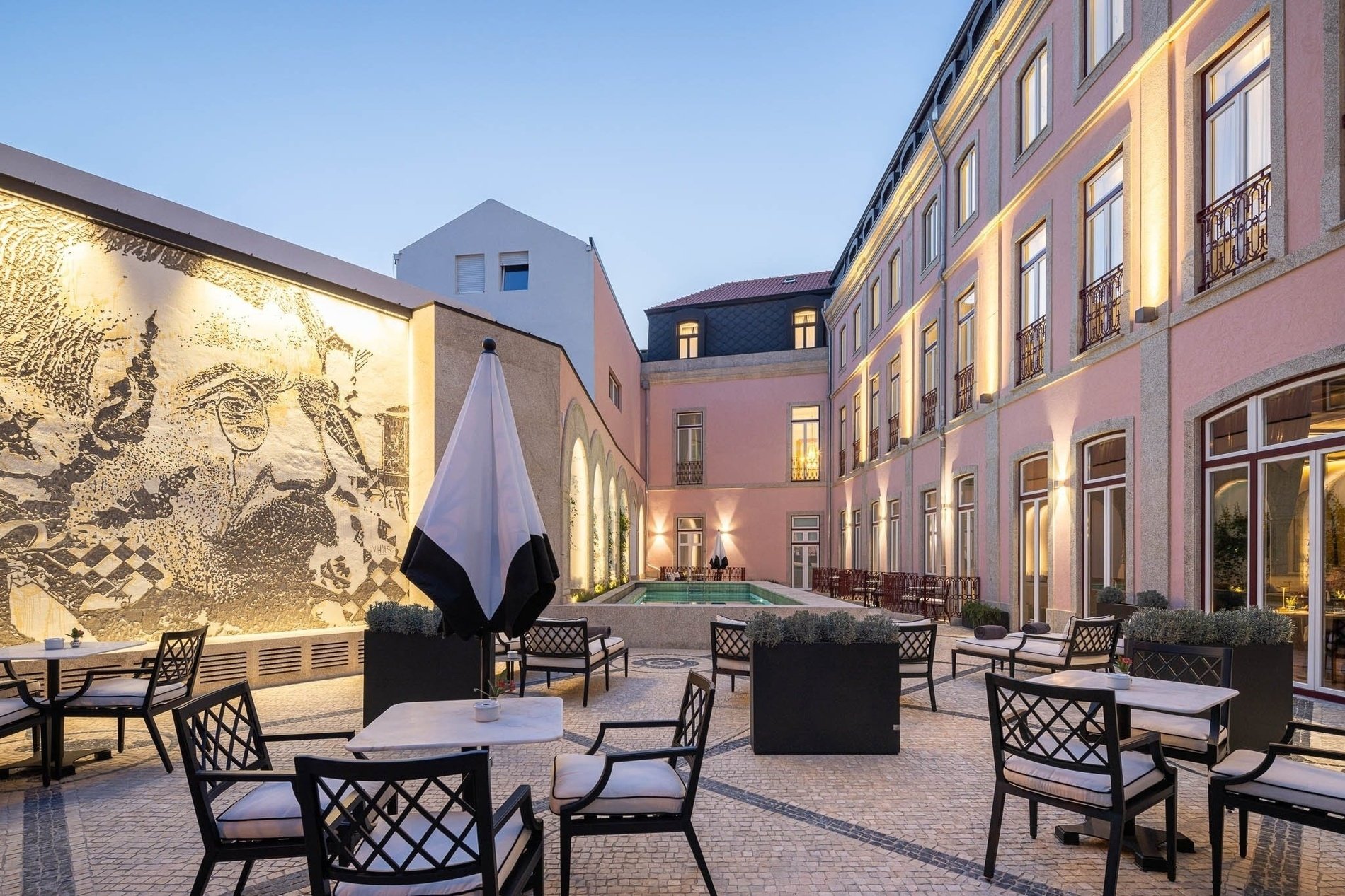 a courtyard with tables and chairs and a pool