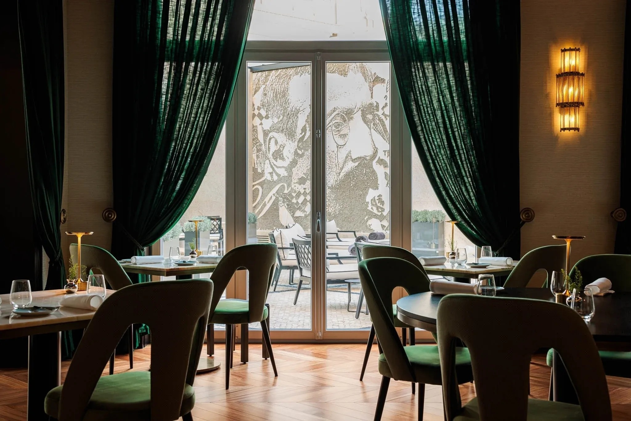 un restaurante con mesas y sillas verdes y cortinas verdes