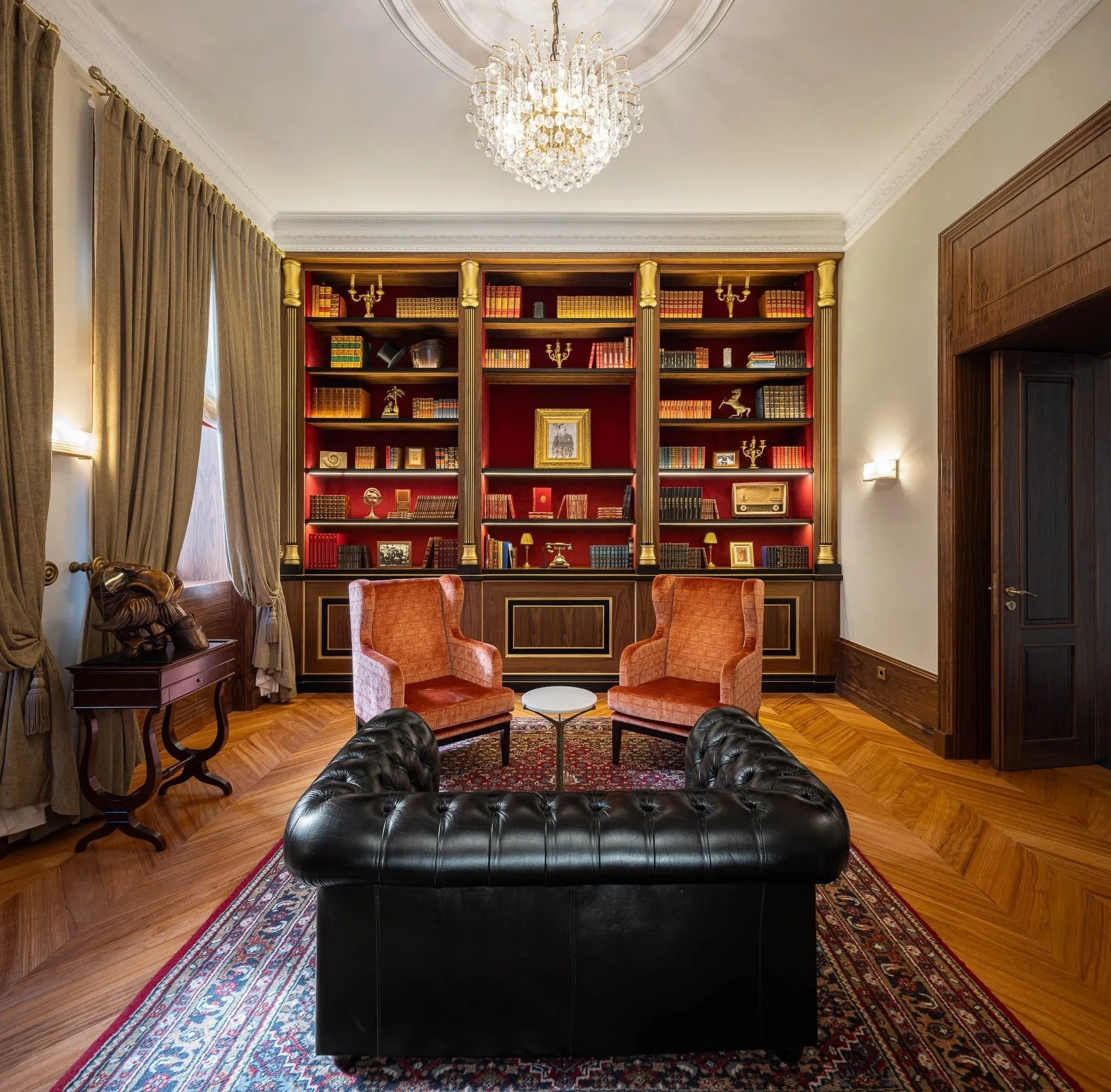 a living room with a black couch and two chairs