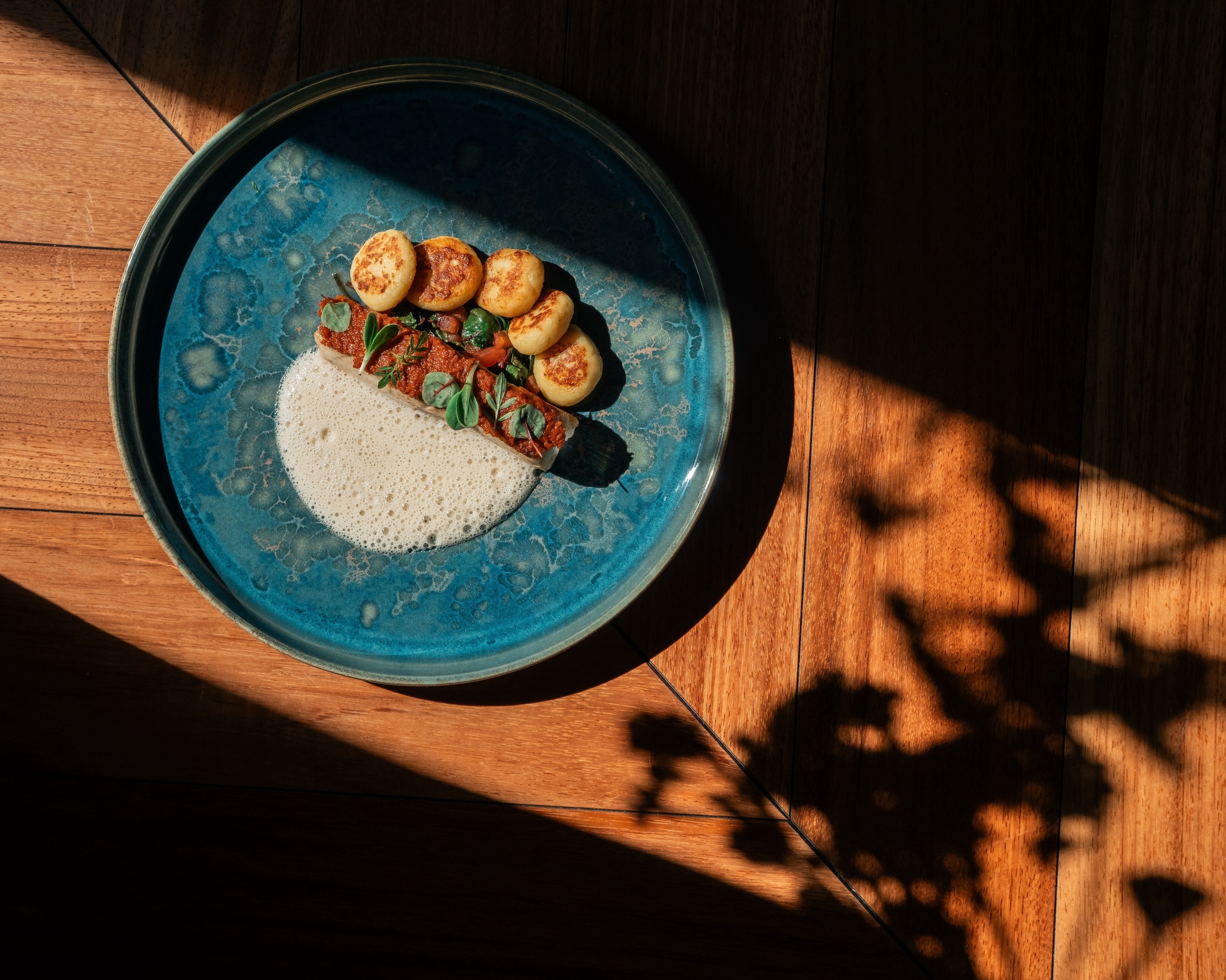 un plato azul lleno de comida está sobre una mesa de madera