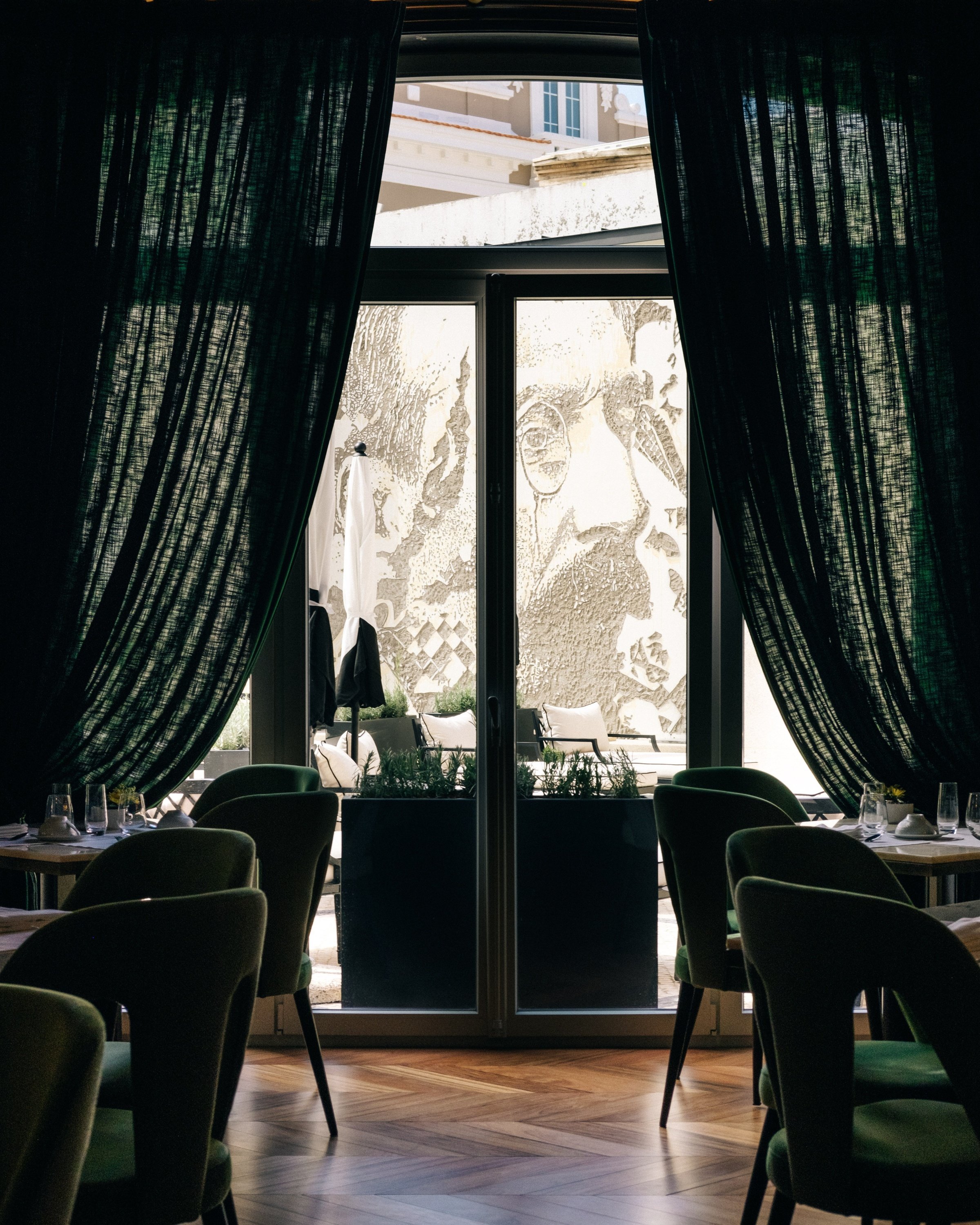 a dining room with green chairs and green curtains