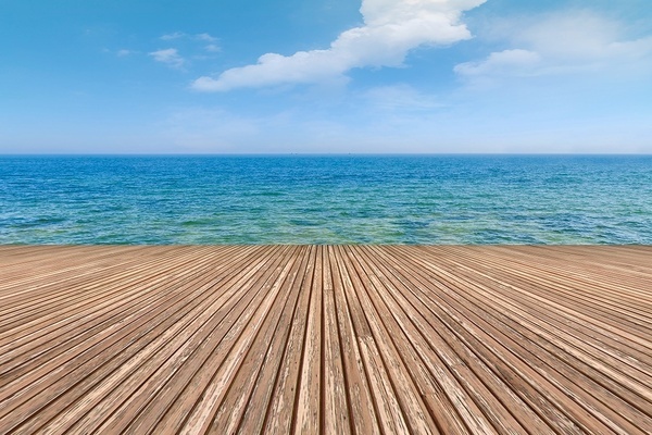 a boat in the ocean with a dock in the background