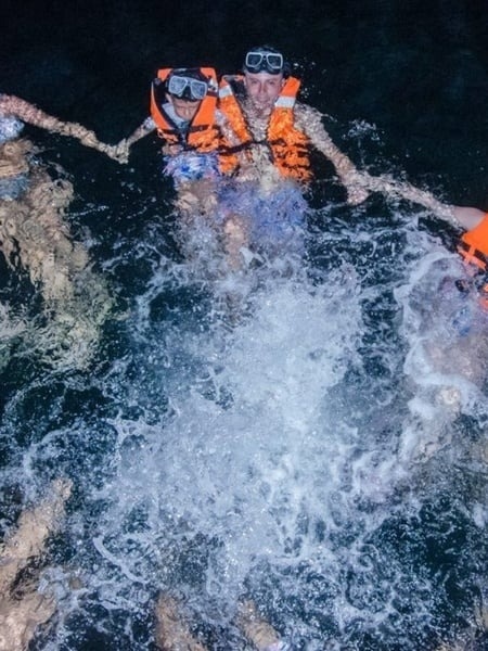 two people wearing life jackets and goggles are swimming in the ocean