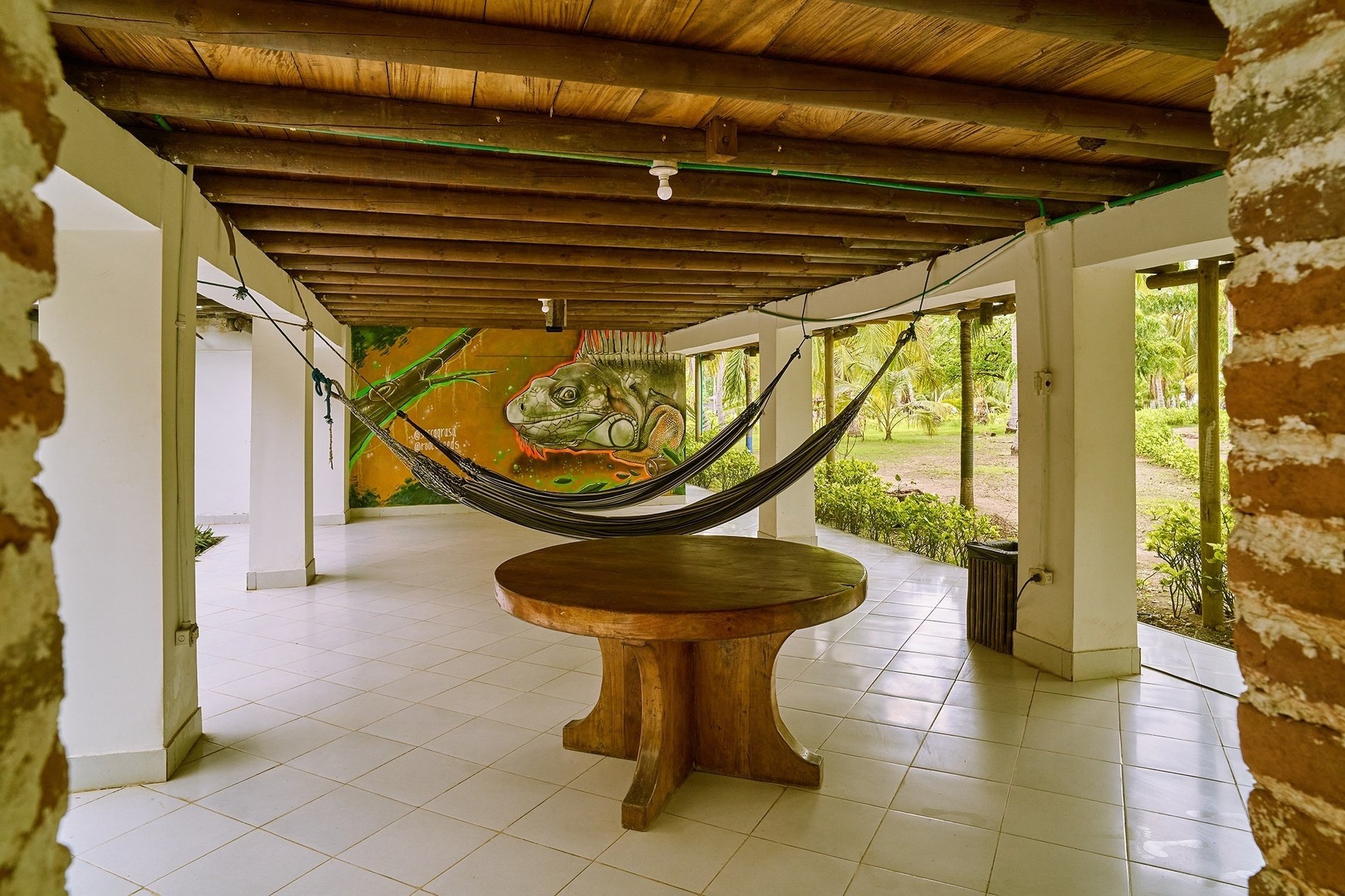 a hammock with a frog painted on the wall behind it