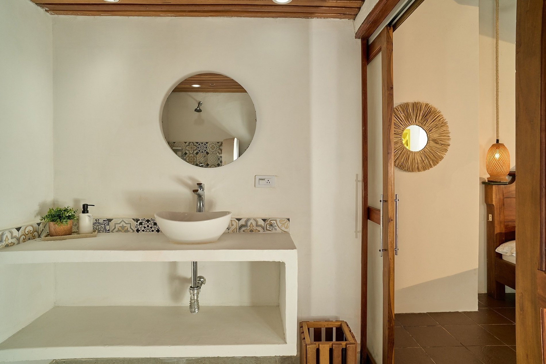 a bathroom with a sink and a round mirror