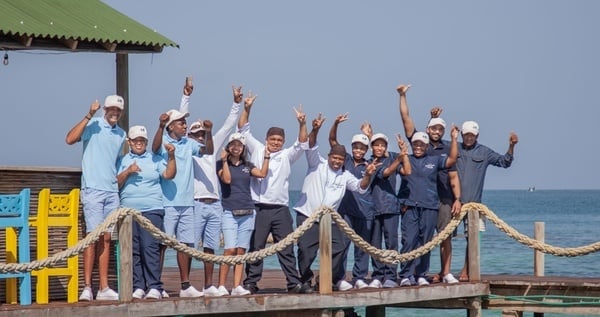 a group of people standing on a dock with their arms in the air