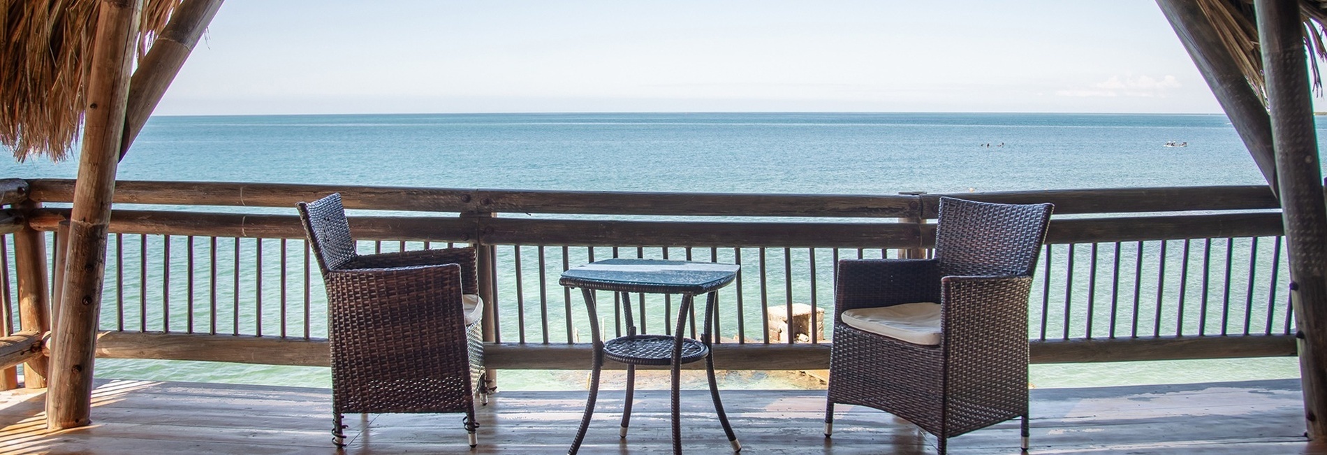 deux chaises et une table sur un balcon avec vue sur l' océan