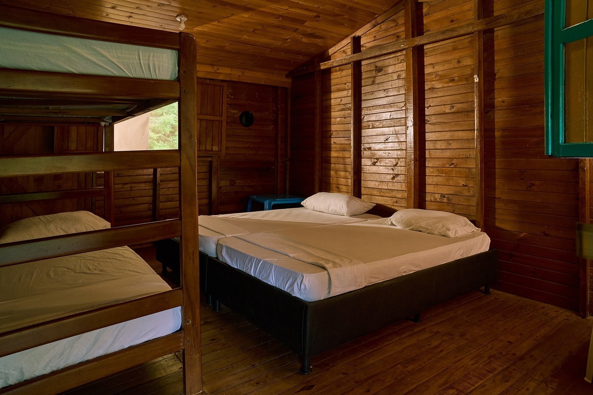 une chambre en bois avec des lits superposés et des lits jumeaux